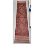 Red ground Meshwani runner with three central lozenge medallions, multiple geometric borders,