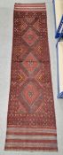 Red ground Meshwani runner with three central lozenge medallions, multiple geometric borders,