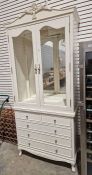 Modern white painted display cabinet chest, the two glazed doors raised over two short and three