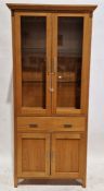 Morris Furniture light oak display cabinet, the top section having two glazed doors opening to