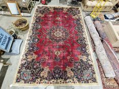 North East Persian signed red ground Meshed carpet with large centralised floral medallion