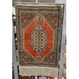 Eastern red ground hanging prayer rug with central foliate hexagon, reserved within fields of