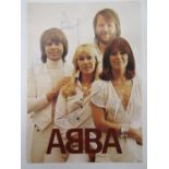 Signed ABBA publicity card featuring a photograph of all four members of the band, signed by each.