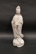 Contemporary blanc-de-chine-style figure of Guanyin, modelled standing on top of a dragon-moulded