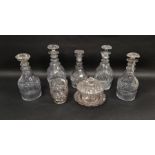 Five Regency cut glass decanters and matched stoppers and a cut glass footed mixing bowl and a