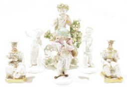 A late 18th century Derby candlestick figure of a putto, a pair of French porcelain figural