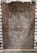 Persian style silk orange ground rug with central floral medallion on floral field and spandrels,