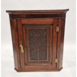 Georgian oak wall hanging corner cabinet with later carved panel to the door of grape and vine