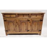 Reproduction oak sideboard having three drawers above three cupboards with carved arched panel