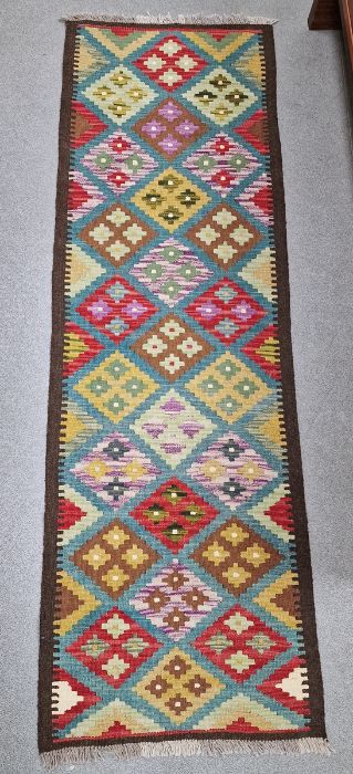 Blue ground Maimana kilim runner with one central row of nine lozenge floral medallions flanked by