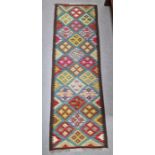 Blue ground Maimana kilim runner with one central row of nine lozenge floral medallions flanked by