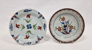 Two late 18th century polychrome English delftware plates, circa 1770, the first painted with a