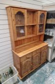 Modern pine dresser, the top with two glazed cabinets and two shelves above three drawers with three