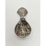 Continental white metal tea caddy spoon with embossed deoration depicting a traditional 19th century
