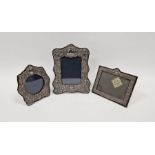 Three Victorian-style silver photograph frames, the largest of scroll outline form cast with putti