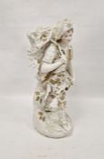 Late 19th century bisque porcelain figure of a woodsman modelled holding a basket of logs forming