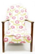 Mid twentieth century wingback oak framed armchair, upholstered in stylised poppy fabric, rush