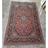 Persian style red ground rug with central floral medallion on floral field and floral spandrels,
