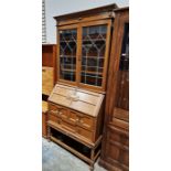 A early 20th century oak bureau bookcase, the top section having two leaded glass glazed doors