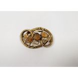 Victorian gold-coloured metal and citrine set brooch of interwoven scrolls and set three stones