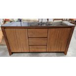 Contemporary teak sideboard with black glass top, three central drawers flanked by cupboards with