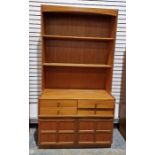 A mid century teak kitchen dresser by Nathan, having two fixed shelves raised over four short