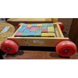Set of children's painted building bricks in stained wood stand with wheels