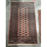 Persian style orange ground rug with two rows of fourteen elephant foot guls and one row of thirteen