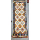 Cream ground Chobi kilim runner with one row of five geometric medallions flanked by tow rows of six