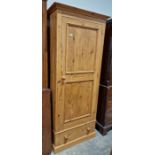 A contemporary pine single door wardrobe over a single long drawer, measuring approx. 183 cm high