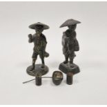 Two Japanese late Meiji (1869-1912) bronze figures of farmers, each modelled wearing a wide-