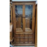 Modern stained oak display cabinet, the two doors fitted with bevel-edged glass panels and having