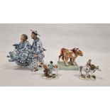 Pair of German small porcelain figures with cattle, modelled carrying baskets of grapes and flowers,