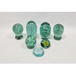 Five Victorian green-tinted dump-shaped weights and two later paperweights, each of the dump weights