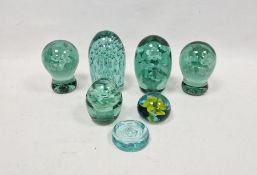 Five Victorian green-tinted dump-shaped weights and two later paperweights, each of the dump weights