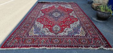 LOT WITHDRAWN - Large Eastern style red ground carpet with central floral medallion flanked by