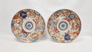 A pair of Japanese Meiji period (1868-1912) imari chargers, printed, painted and gilt with a central