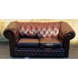 20th century leatherette upholstered Chesterfield two-seat sofa raised on castors, 162cm long