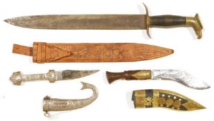 Two daggers, one Nepalese, brass-mounted applied with three coins and engraved bands to the