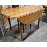 Modern stained wood extending dining table, oval, on turned supports with six extending leaves,