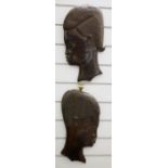 Pair of 20th century African carved hardwood wall hangings of man and woman in profile, 38.5cm