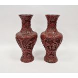 Pair of Chinese carved cinnabar vases, each carved with dense scrolls and flowerheads above panels