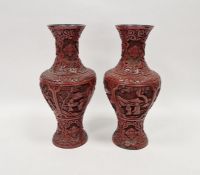 Pair of Chinese carved cinnabar vases, each carved with dense scrolls and flowerheads above panels