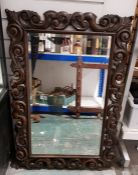 20th century oak framed bevelled edge wall mirror, of rectangular form, with carved scrolling