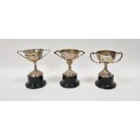 Three early to mid 20th century unengraved silver trophies, one with weighted base, each having twin