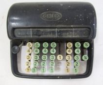 Vintage Contex bakelite adding machine in black, and a black metal first aid box by John Bell and