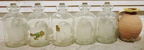 Five glass demijohns and a red stoneware jug (6)