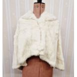 A vintage ermine cape, hooded, the back slightly longer than the front, with circular fur button