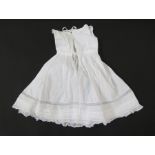 An Edwardian child's lawn cotton nightdress/petticoat, pintuck and frill detail, long sleeves with