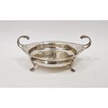 Silver shallow bowl with scroll pierced everted rim, pair of foliate free scroll handles on four paw